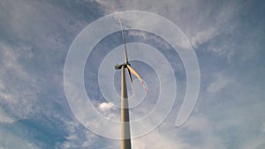 Wind turbine eco farm on beautiful golden hour evening mountain landscape.