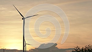 Wind turbine farm on beautiful golden sky evening landscape. Renewable energy production for green ecological world