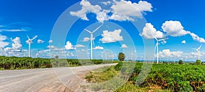 Wind turbine farm in beautiful nature with blue sky blackground, generating electricity