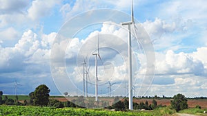 Wind turbine farm in beautiful nature with blue sky blackground, generating electricity