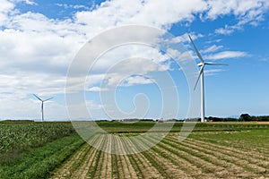 Wind turbine and farm with blue sky