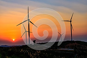 Wind turbine farm over sunset