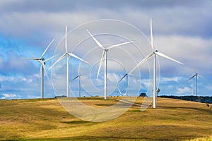Wind turbine farm windmills creating energy on top of hill