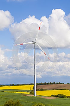 Wind turbine generating electricity on blue sky