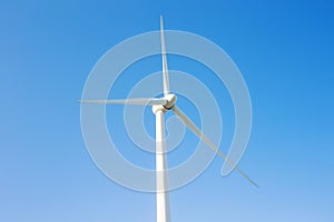 Wind turbine generating electricity with blue sky - energy conservation concept