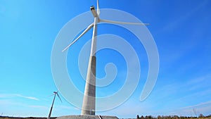 Wind turbine generating electricity on blue sky. Low angle view.