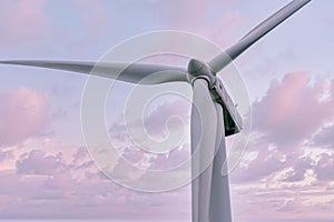 Wind turbine generating electricity clean energy with cloud and sunlight background on the sky. Clean energy concept.