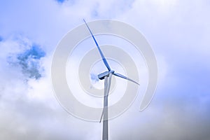 Wind turbine generating electricity clean energy with cloud and sunlight background on the sky. Clean energy concept.