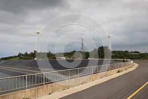 Wind turbine generating electricity on Lam Takong reservoir dam