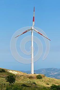 A wind turbine generating electricity on a plain in Sicily, Italy