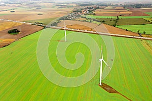 Wind turbine generating electricity, windmills against the background of a green field, an alternative source of energy, view from