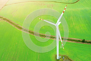 Wind turbine generating electricity, windmills against the background of a green field, an alternative source of energy, view from