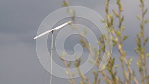 Wind turbine generator and spring tree branches. Static focus change shot