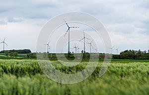 Wind turbine on green fields in summertime. Natural wind power plants and sustainable eco-friendly energy resource