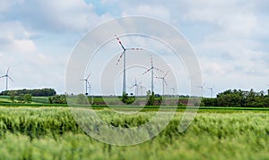 Wind turbine on green fields in summertime. Natural wind power plants and sustainable eco-friendly energy resource