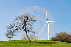Wind turbine on a green hill.