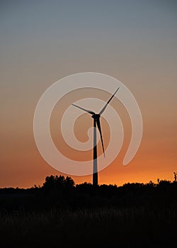 Wind turbine  on the hill at sunset