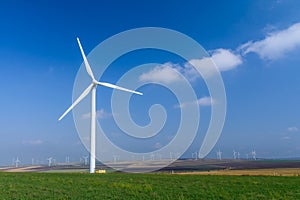 Wind turbine on the meadow on background of skies. Colorful pict