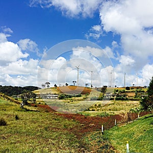 Wind turbine on the mountain with a cloudy blue sky