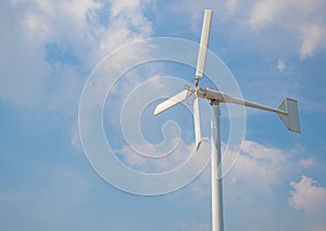 Wind turbine producing alternative energy on cloudy sky background