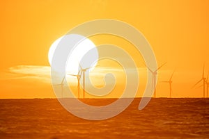 Wind turbine on the sea during sunset. Renewable energy sources. Technology and production.