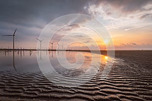 Wind turbine on the seaside of Taiwan west coast at sunset with sunset colors and golden hour colors