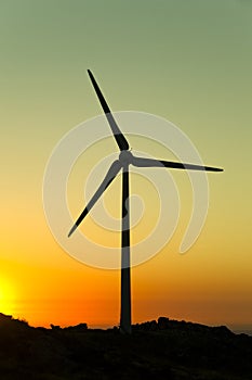 Wind turbine silhouette on sunset background photo