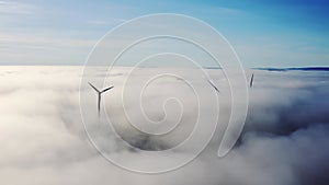 Wind turbine Sitting above heavy fog,mist on a early morning sunrise in south wales uk. Wind farm generating green