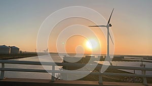 Wind turbine and solar panel farm in green energy and renewable energy farm. Shot during sunset.