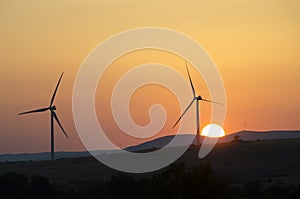 Wind turbine and sun on sunset