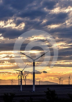 Wind turbine at sunset with beautiful clouds