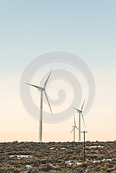 Wind turbine tower with sunset sky background in counter side, winter season..