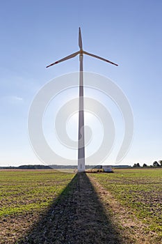 Wind turbine under blue sky at sunset, renewable energy concept photo