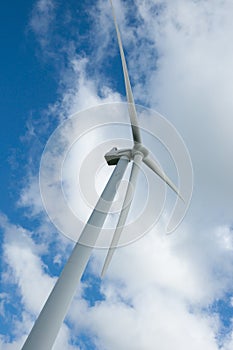 Wind turbine under cloudy sky.