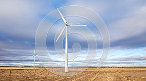 Wind turbine in wheat fiel and cloudy photo