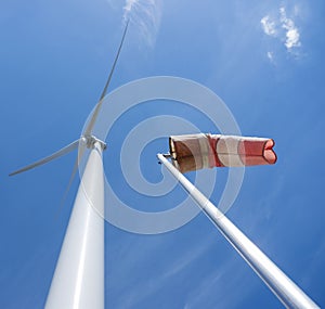 Wind turbine and windbag against blue sky