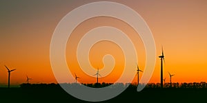 Wind turbines against beautiful sunset sky. Eolic park. Eco farm of clean energy