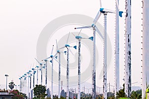 Wind turbines arranged in rows with bright sunlight. Conservation and sustainable energy concept.