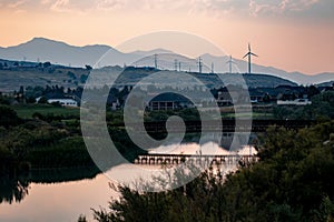 Wind turbines beyond a beautiful river setting