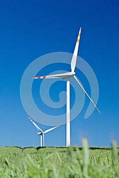 Wind turbines and blue sky from grass level