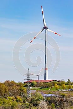 Wind turbines dominate the landscape next to power poles and photovoltaic panels in Germany