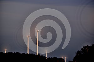 Wind turbines at dusk, blades look like wheels