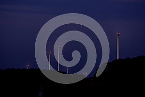 Wind turbines at dusk, blades look like wheels