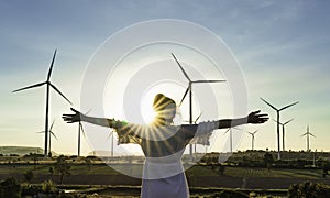 Wind turbines farm is an alternative electricity source, Concept of sustainable resources, Renewable energy concept, Girl standing