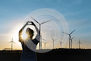 Wind turbines farm is an alternative electricity source, Concept of sustainable resources, Renewable energy concept, Girl standing