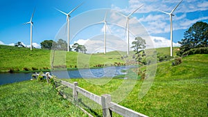 Wind turbines farm on a green grass hills