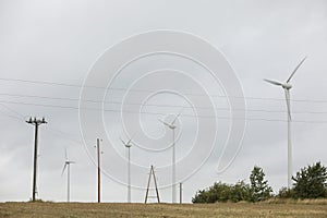 Wind turbines field in a stormy day with strong wind and rain. Wind farm eco field. Green ecological power