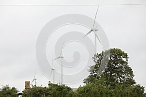 Wind turbines field in a stormy day with strong wind and rain. Wind farm eco field. Green ecological power