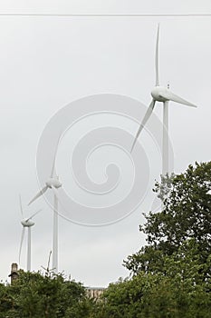 Wind turbines field in a stormy day with strong wind and rain. Wind farm eco field. Green ecological power