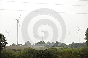 Wind turbines field in a stormy day with strong wind and rain. Wind farm eco field. Green ecological power